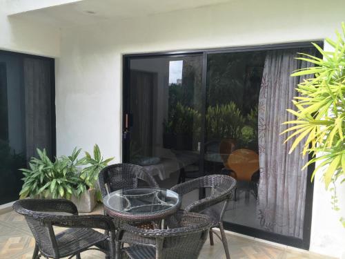 a patio with chairs and a table and a balcony at Villa Costa Chica Comodisimo piscina gigante jardines in Acapulco
