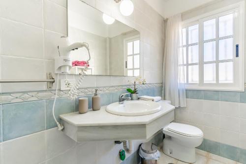 a bathroom with a sink and a toilet and a mirror at Penthouse with ocean views - Torviscas in Adeje