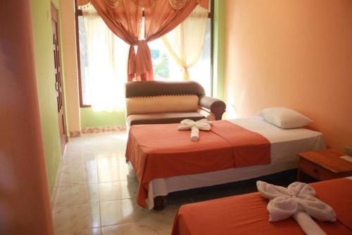 a bedroom with two beds and a window at La Casa De Mi Sub in Puerto Baquerizo Moreno