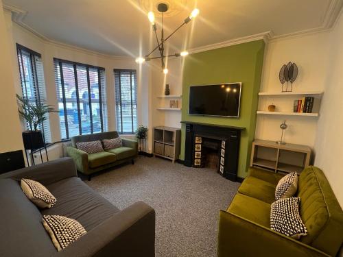 a living room with two couches and a television at 4 bedroom 2 bath beautiful Victorian house in Nottingham