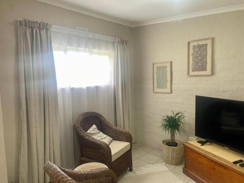 a living room with a chair and a television at 42 On Fraser in Howick