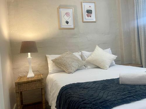 ホウィックにある42 On Fraserの枕とランプが付いたベッドのある寝室