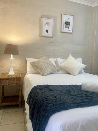 a bedroom with a large bed with a blue blanket at 42 On Fraser in Howick