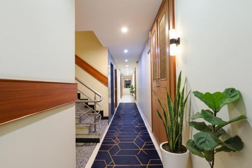 een hal met planten en trappen in een huis bij FabHotel RKH Skylink Residency in Chennai