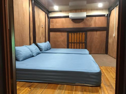 a large bed with blue pillows in a room at Bee Lucky Homestay in Hai Phong