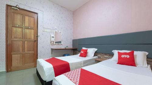 Kampong Salengにあるhotel hen henのベッドルーム1室(赤と白のベッド2台付)