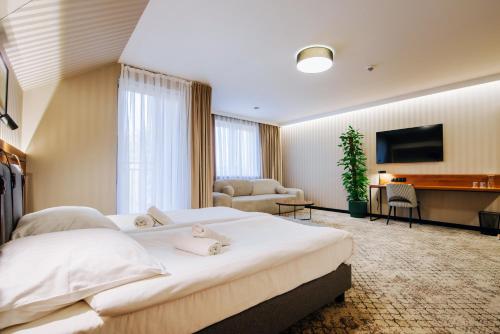 a hotel room with a large bed and a desk at Hotel Cztery Pory Roku in Głogów Małopolski