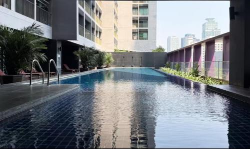 une piscine au milieu d'un immeuble dans l'établissement Noble Remix Thonglor - Direct BTS Access - Super Fast Wi-Fi, à Bangkok