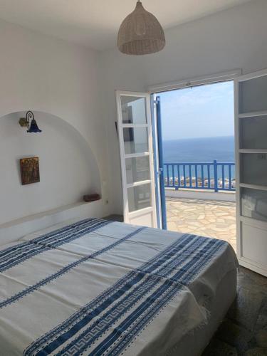 a bedroom with a bed with a view of the ocean at Villa Argos in Agios Georgios