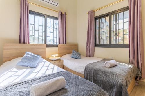 a bedroom with two beds and a window at Daya 2BR Apartment In Batroun in Batroûn