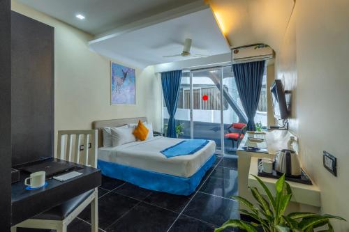 a hotel room with a bed and a desk and a television at Afallon Hotels in Bangalore