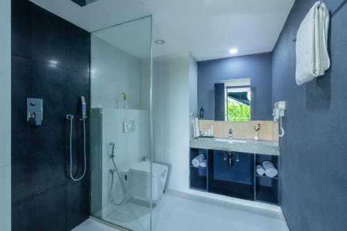 a bathroom with a toilet and a sink and a shower at Afallon Hotels in Bangalore