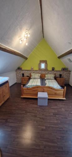 a bedroom with two beds and a green wall at Ferienhaus an See in Nohfelden