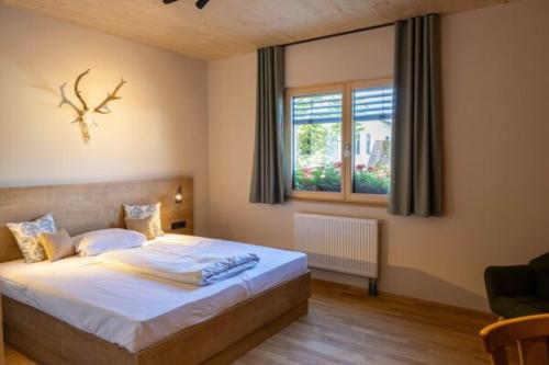 ein Schlafzimmer mit einem Bett mit weißen Laken und einem Fenster in der Unterkunft Zum Posthalter in Hemau