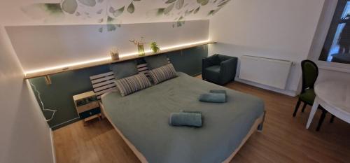 a small bedroom with a bed and a table and chairs at Le Refuge Aristide - Cozy - 4ch - Grand parking gratuit in Cravanche