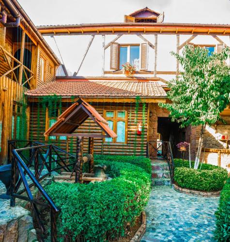 a house with a garden in front of it at Khan Lankaran Hotel in Lankaran