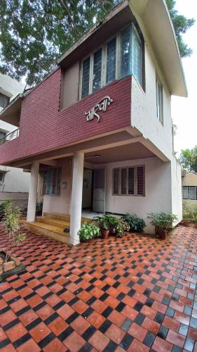 a house with a red roof and a brick driveway at The Nest - Garwa in Miraj
