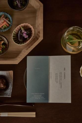 a book sitting on a table with plates of food at KÚON Hakone Gora in Hakone