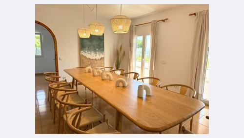 a dining room with a wooden table and chairs at Villa Truvi in Cala Galdana