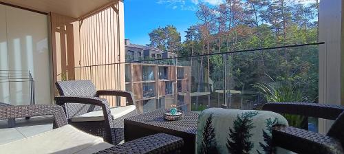 Il dispose d'une terrasse avec une table et des chaises. dans l'établissement Sea & Forest - Apartamenty Może nad Morze, Parking, basen, siłownia GRATIS, à Międzyzdroje