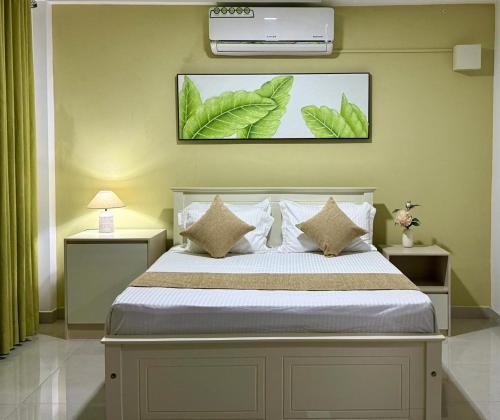 a bedroom with a bed with leaves on the wall at Opal Heights in Gampaha