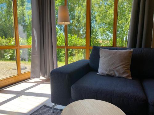 un salon avec un canapé bleu devant une fenêtre dans l'établissement Natur Ferienpark 1 - Typ A, à Nieheim