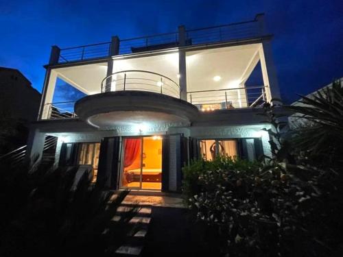 een groot huis 's nachts met de lichten aan bij Seafront Villa Montenegro1 min to the Sea in Baošići