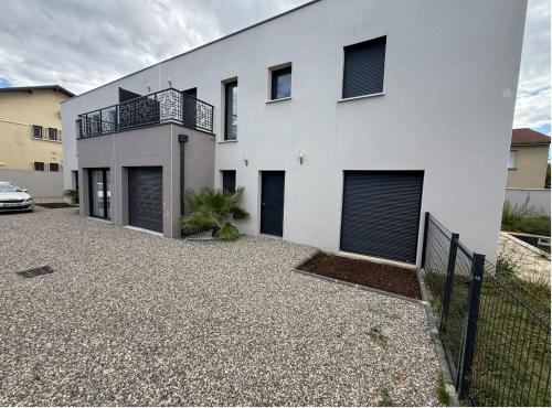 a white house with a car parked in front of it at Éclipse in Vénissieux