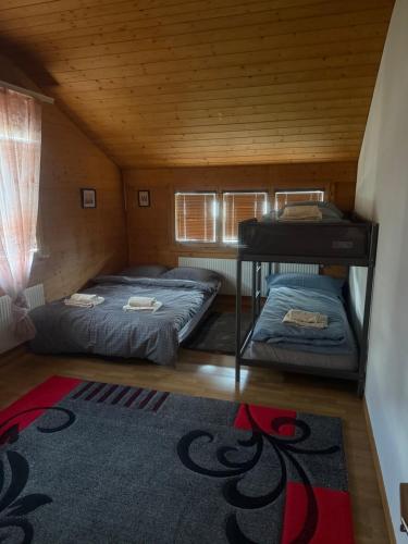 two beds in a small room with a rug at Ferienwohnung Happy Life Thun in Steffisburg