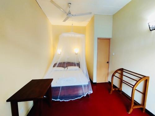 a bedroom with a bed with a mosquito net at Why Not Guest house - Hikkaduwa in Hikkaduwa