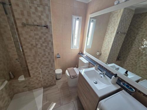 a bathroom with a sink and a shower and a mirror at Palm Breeze - Las Americas in Playa de las Americas
