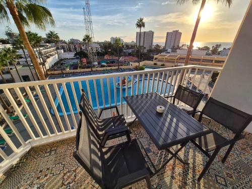 a table and chairs on a balcony with a view of the water at Palm Breeze - Las Americas in Playa de las Americas