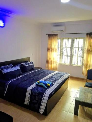 a bedroom with a large bed with a blue comforter at Short Let Apartments in Lagos Business School Lekki Ajah in Lekki