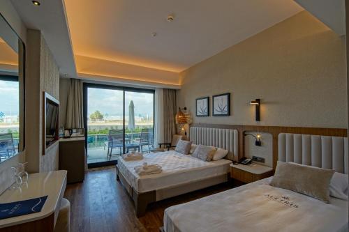 a hotel room with two beds and a large window at Aletris Deluxe Hotel & SPA in Side