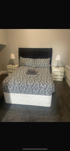 a bed with a black and white comforter and two nightstandumentsuments at Levy Nook 8 in Darlington