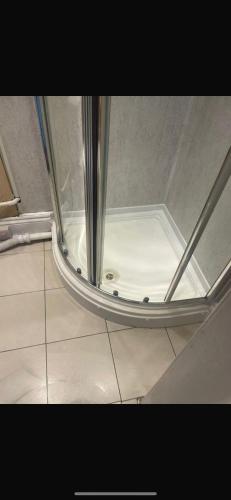 a shower with a glass door and a tile floor at Levy Nook 8 in Darlington