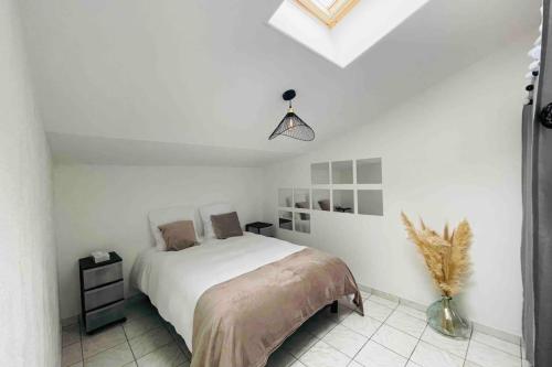 ein Schlafzimmer mit einem Bett in einem weißen Raum in der Unterkunft La petite maison du Loubat avec jardin in Asnières-la-Giraud