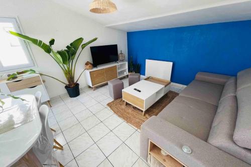 ein Wohnzimmer mit Sofa und Fernseher in der Unterkunft La petite maison du Loubat avec jardin in Asnières-la-Giraud