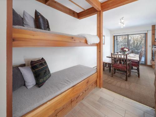 a room with a bunk bed and a dining room at RMR: Chokeberry 3813 Condo in The Aspens in Wilson