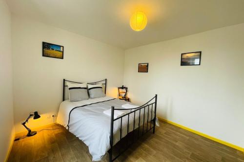 une chambre avec un lit et une lampe dedans dans l'établissement Le Faubourg, à Saint-Jean-dʼAngély