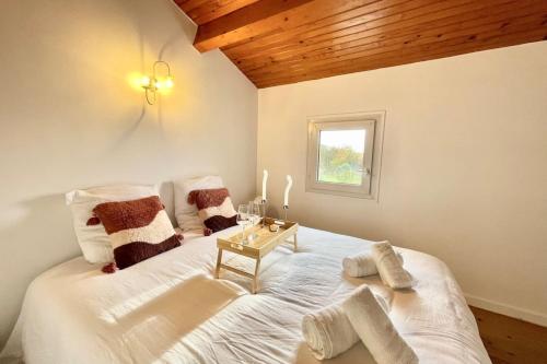 Una cama blanca grande en una habitación con ventana. en La Touzetterie avec SPA-cour privée, en Saint-Jean-dʼAngély