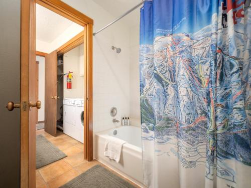 a bathroom with a tub and a shower curtain at RMR: Chokeberry 3814 Condo in The Aspens in Wilson