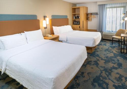 a hotel room with two beds and a table at Hampton Inn Tampa International Airport/Westshore in Tampa