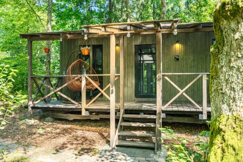 una pequeña cabaña en el bosque con un árbol en Meža māja, en Zaķumuiža