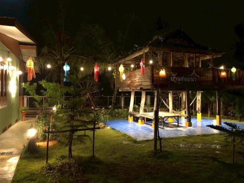 een gebouw met lichten er 's nachts voor bij สมายด์ ฮ่อมนา เรสเฮาท์ Smile Homna Resthouse in Ban Mae Chong