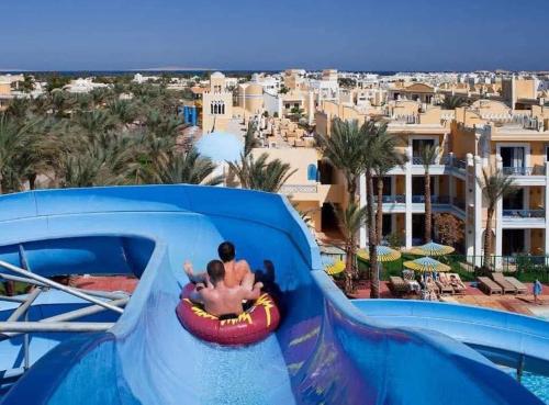 a couple riding a water slide at a resort at Mirage Bay hotel in Hurghada