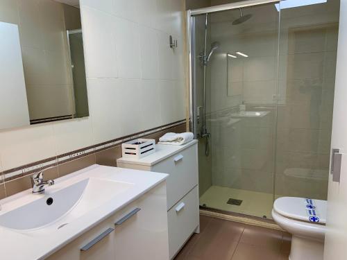 a white bathroom with a sink and a shower at Apartamento puerto Benicarlo in Benicarló