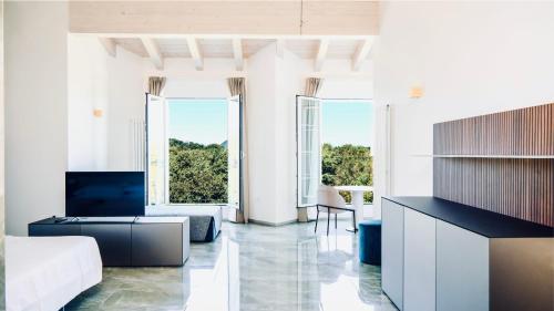 a living room with white walls and large windows at Bellavista Terme Resort & Spa in Montegrotto Terme