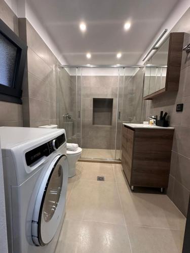 a bathroom with a washing machine and a toilet at Helios 1 in Chios
