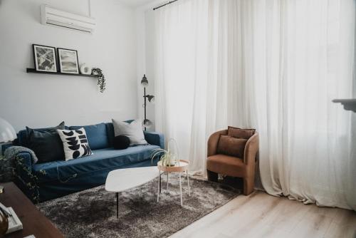 a living room with a blue couch and a chair at Your home on Smith St Collingwood Melbourne with parking in Melbourne